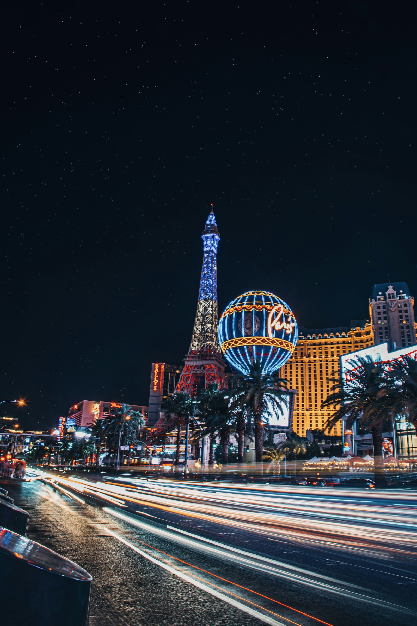 A Strip de Las Vegas à noite com rastros de luz e a Torre Eiffel do Paris Las Vegas